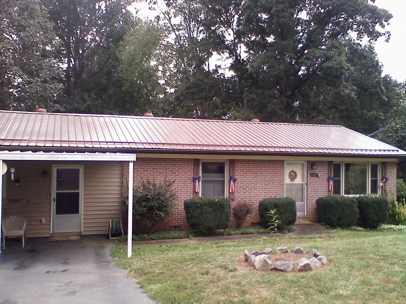 Bronze metal roof and carport on a brick ranch home — Roof Repair work by our crew in Homestead